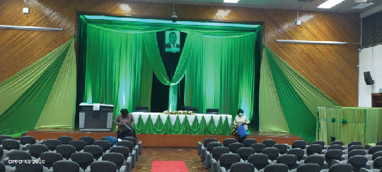 Conference stage with green draping and seating