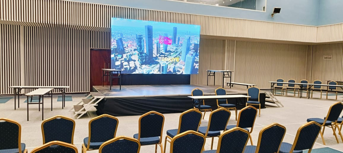 Conference hall with a wide LED screen and rows of seating