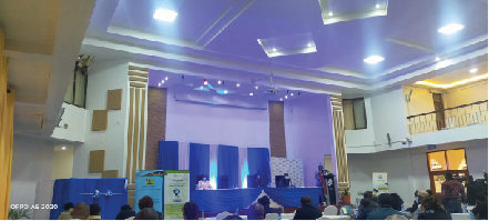 Conference hall with blue chairs and a stage