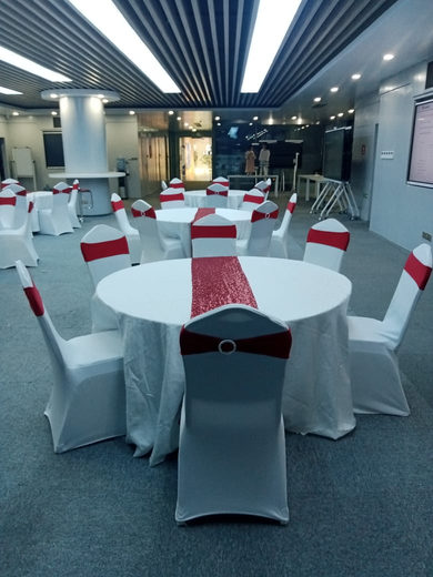 Round tables with white covers and red sashes